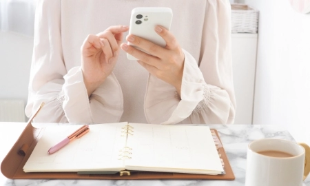 スケジュールをチェックする女性の画像