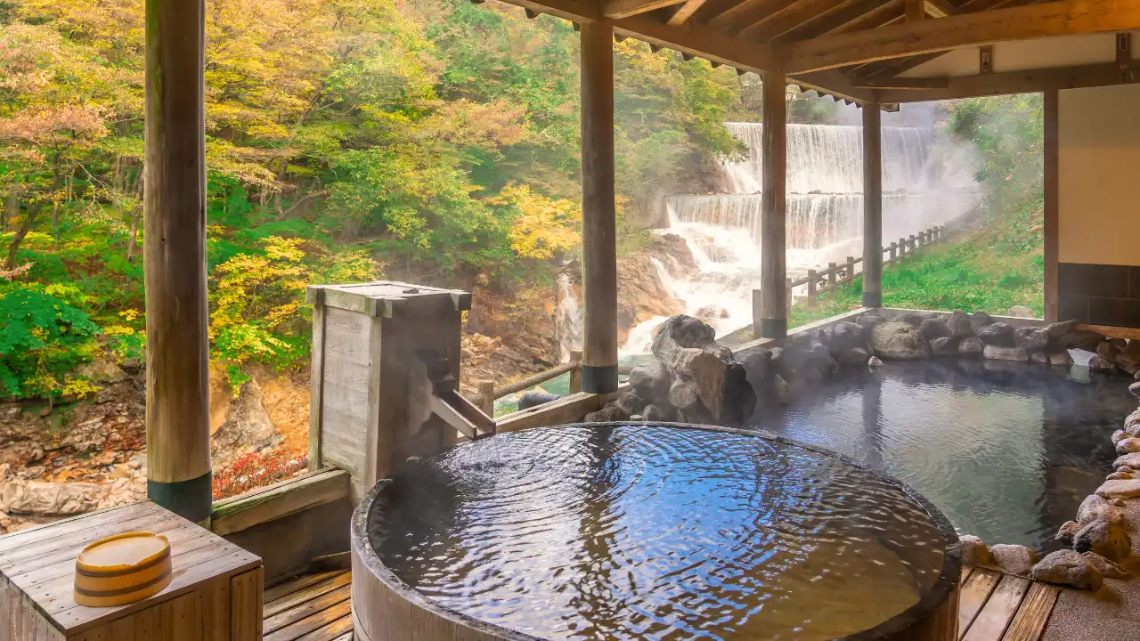 紅葉と川が流れる背景。丸と長方形の二つの種類の露天風呂の画像